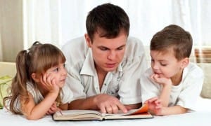 Папа с детьми читают книгу